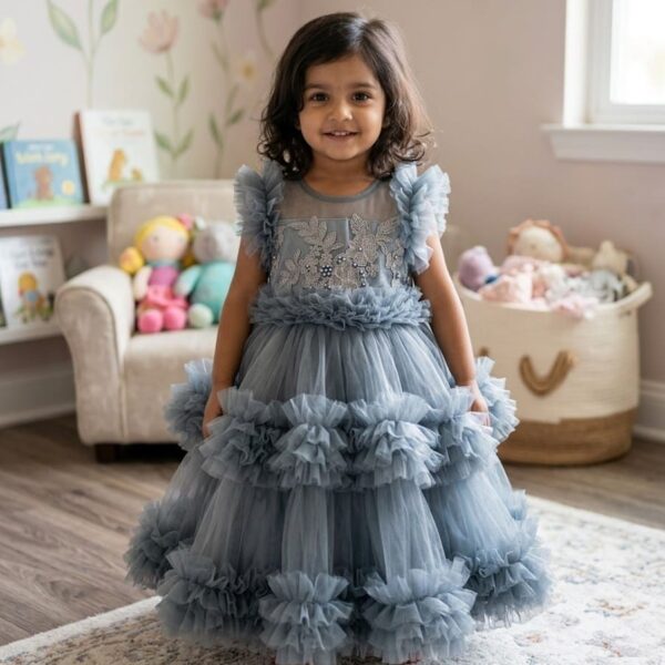 Little girl wearing a premium ash grey layered ruffle party dress with silver floral embroidery and pearl details.