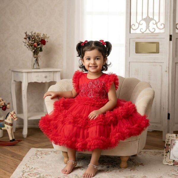 Red ruffle tulle party dress for baby girl with heavy bodice embroidery and flutter sleeves.