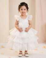 Little girl in a beautiful snow white layered net party dress with large 3D rose and pearl neck design.