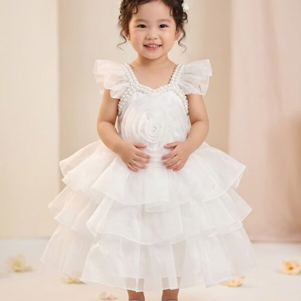 Little girl in a beautiful snow white layered net party dress with large 3D rose and pearl neck design.
