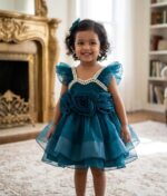 Baby girl in a teal blue luxury net party frock with 3D roses and pearl neckline.
