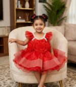 Little girl wearing a premium red party dress featuring large 3D organza roses on the front and a pearl-studded neckline