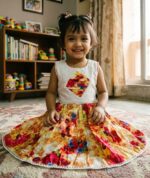 White sleeveless baby girl dress with colorful floral print skirt and diamond-shaped chest embroidery.